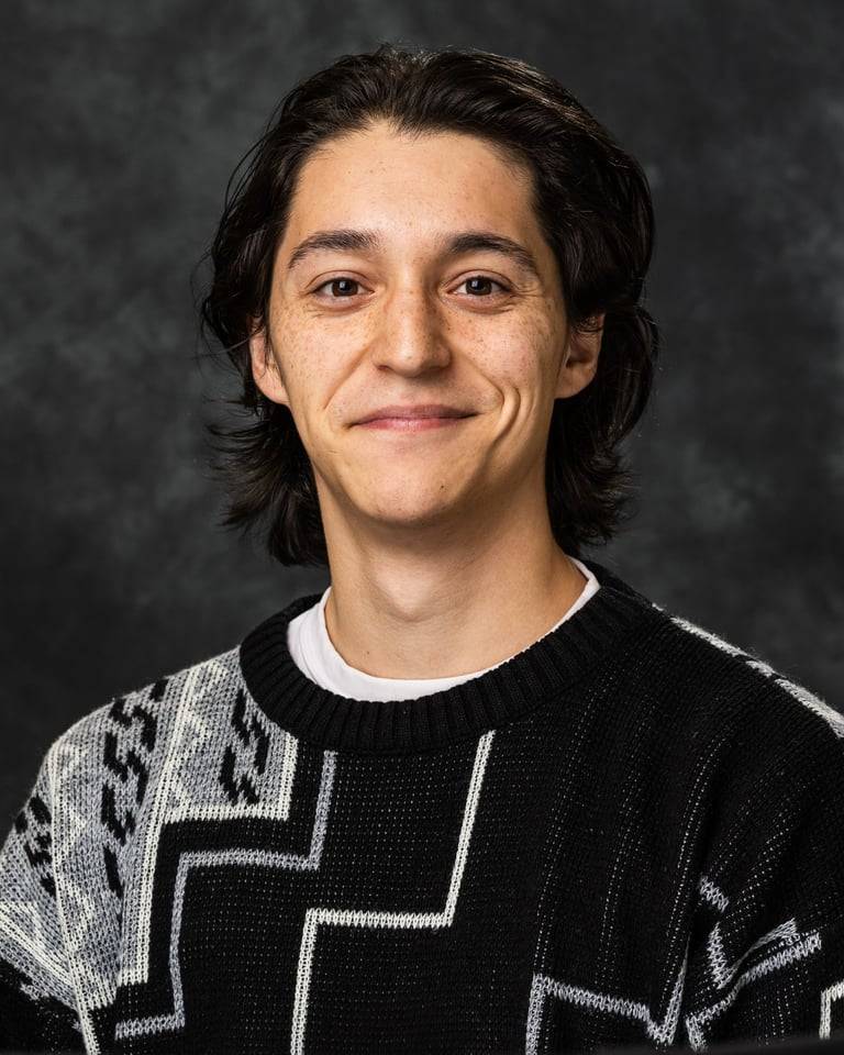 Person posing for a headshot in a gray sweater.